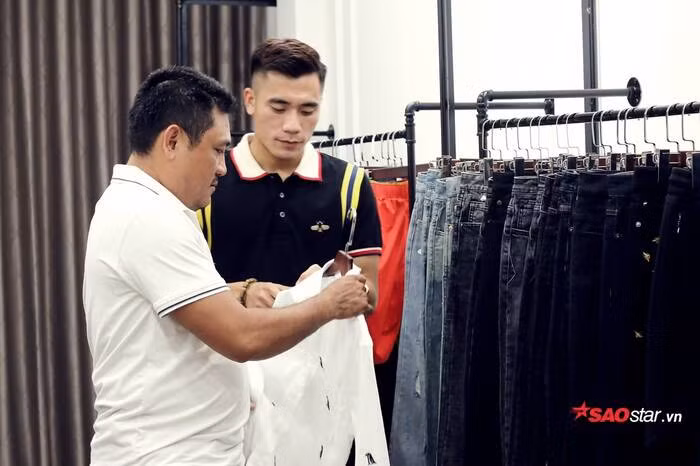 Hình ảnh Bùi Tiến Dụng tư vấn áo cho khách hàng.