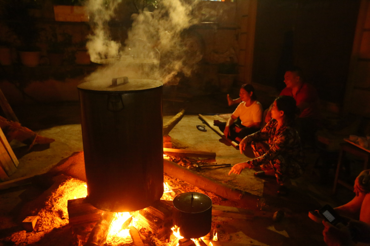 Chị Hồng Tâm cùng với gia đình gồm ba thế hệ nhiều con cháu cùng nhau thức canh nồi bánh chưng, bếp lửa hồng tại một góc sân trong ngõ 342 Khương Đình (quận Thanh Xuân, Hà Nội). Năm nay gia đình chị nấu khoảng hơn 200 cái bánh chưng.