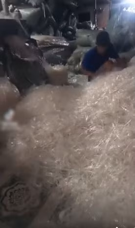 Hàng loạt các sợi bánh tráng được cắt nhỏ vụn rơi vãi khắp sàn nhà, thậm chí khi cho vào túi bóng to, các nhân viên ở đây còn dùng chân giẫm lên cho xẹp xuống.