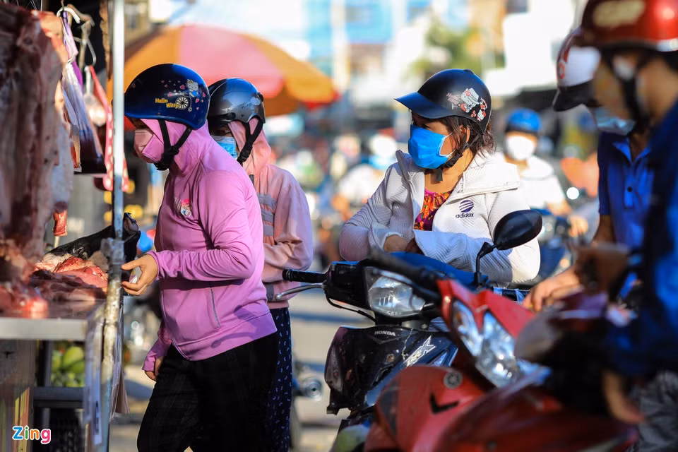Người đến chợ tự phát đều đeo khẩu trang nhưng chợ quá đông khiến việc giãn cách tối thiểu 1,5 m không được thực hiện. Trong ảnh, người dân dừng xe đừng chờ mua thịt trên đường Phan Văn Hớn, huyện Hóc Môn, TP.HCM.