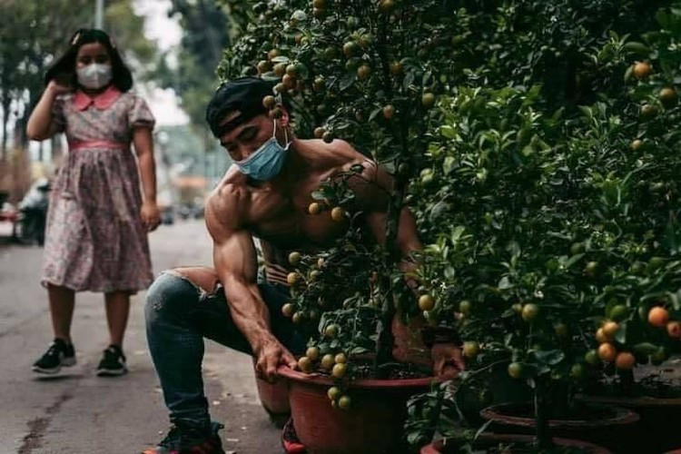 Điều đặc biệt đó là chàng trai 6 múi này nhìn lực lưỡng vậy nhưng cực kỳ chịu khó, vừa đứng ngoài vỉa hè chào mời bán quất cảnh vừa chăm chút, tưới nước cho từng chậu cây cực kỳ cẩn thận.