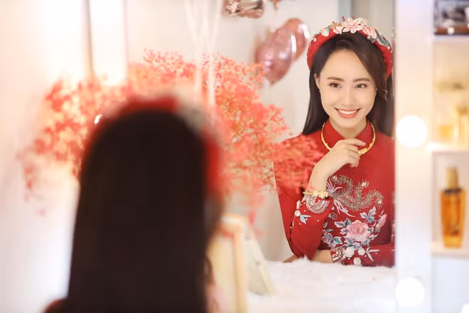 Chiếc áo dài ăn hỏi của nữ MC Xuân Anh được thêu hoa nổi và điểm nhấn là chi tiết phía trước ngực khá kì công.