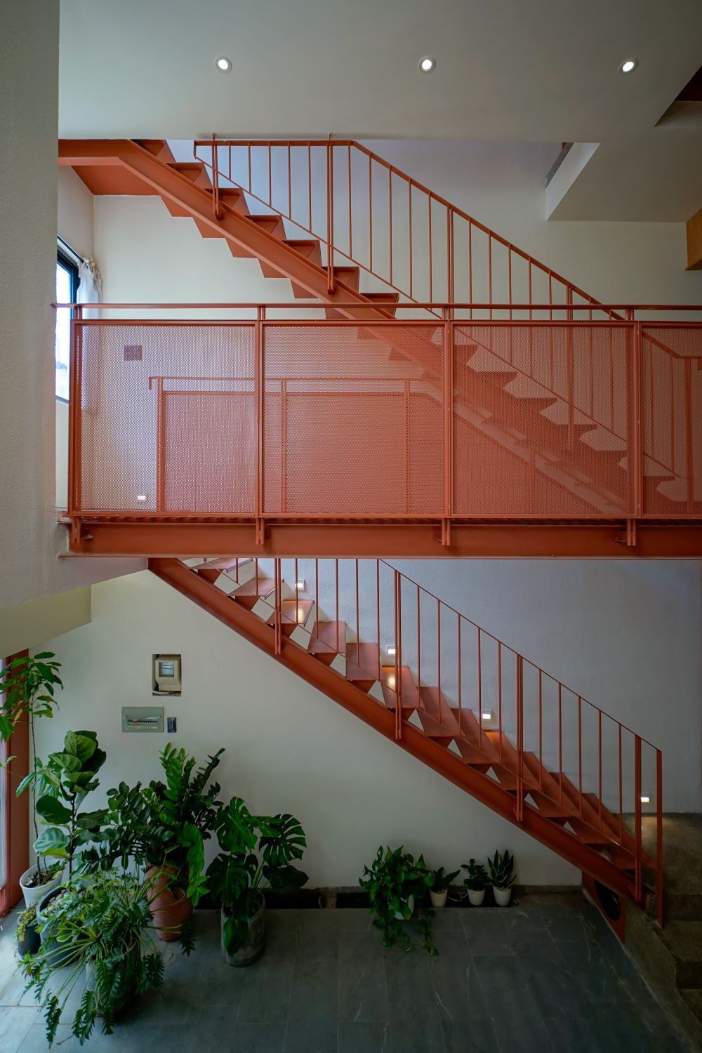 Căn nhà có hệ thống thang sắt được sơn màu đỏ làm điểm nhấn, làm tăng tính trẻ trung, năng động của không gian.