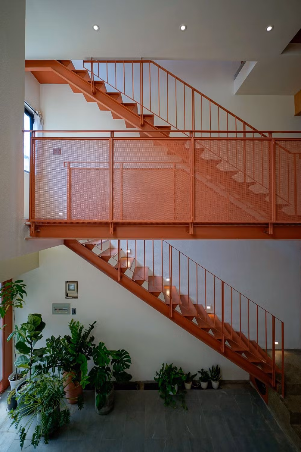 Căn nhà có hệ thống thang sắt được sơn màu đỏ làm điểm nhấn, làm tăng tính trẻ trung, năng động của không gian.