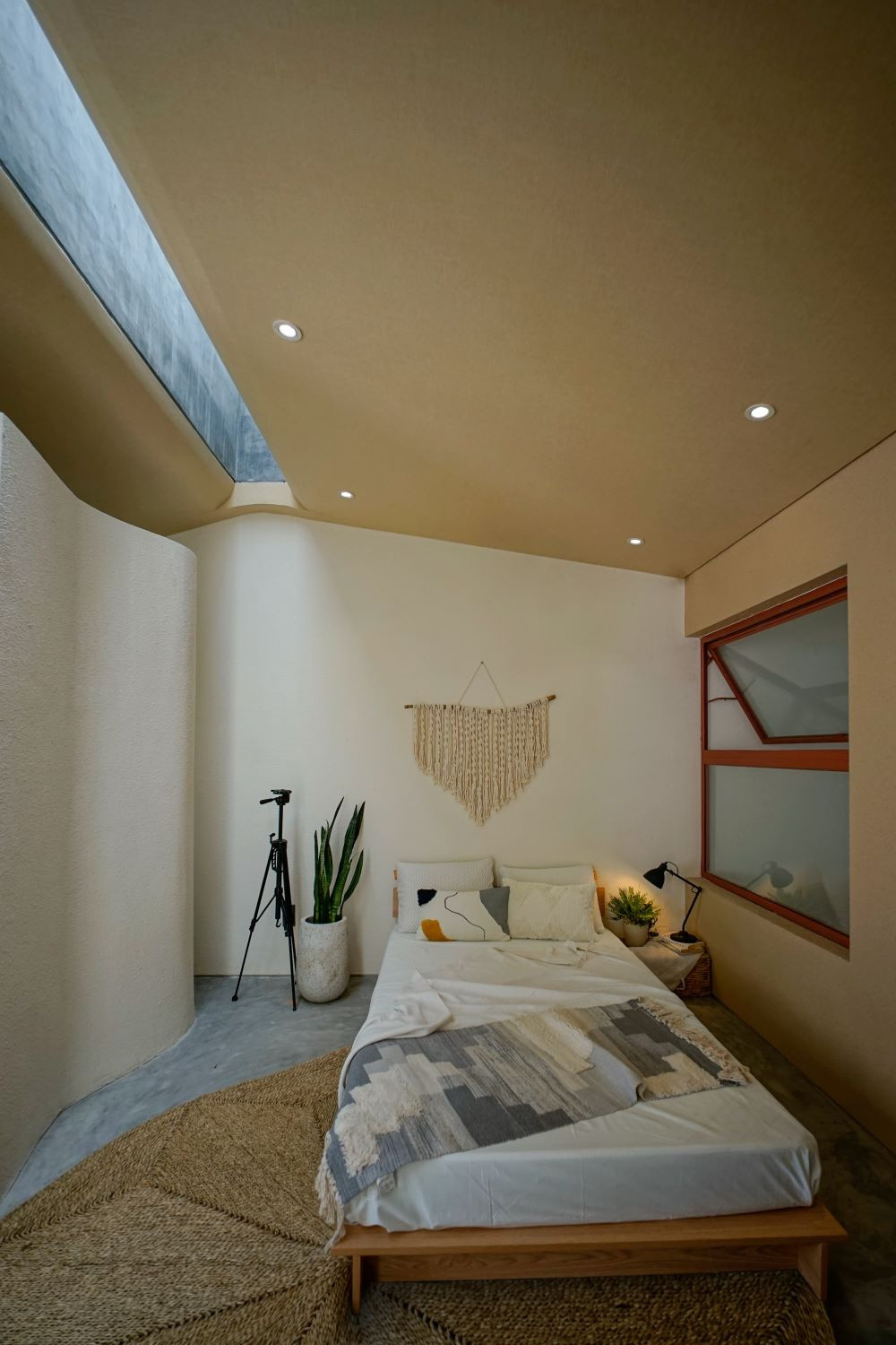Một giường ngủ nhỏ được bố trí trong studio được thiết kế với khả năng đón ánh sáng tự nhiên.