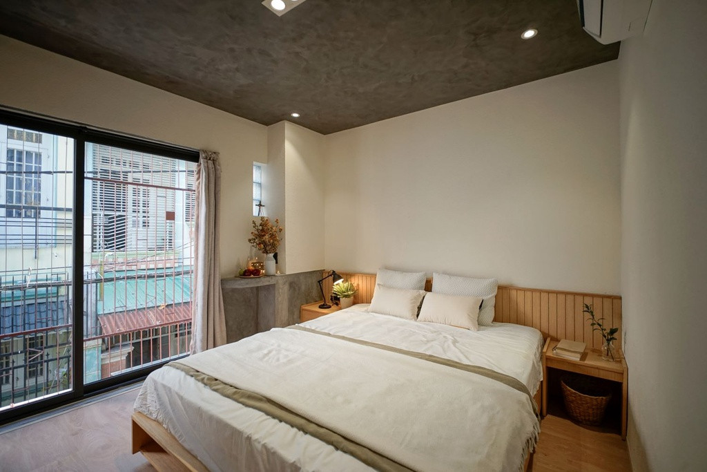 Phòng ngủ chính của hai vợ chồng được bố trí trên tầng cao với thiết kế đơn giản, ấm cúng và ngập tràn ánh sáng tự nhiên. Các không gian sinh hoạt của gia chủ được thiết kế đảm bảo tính riêng tư hơn.