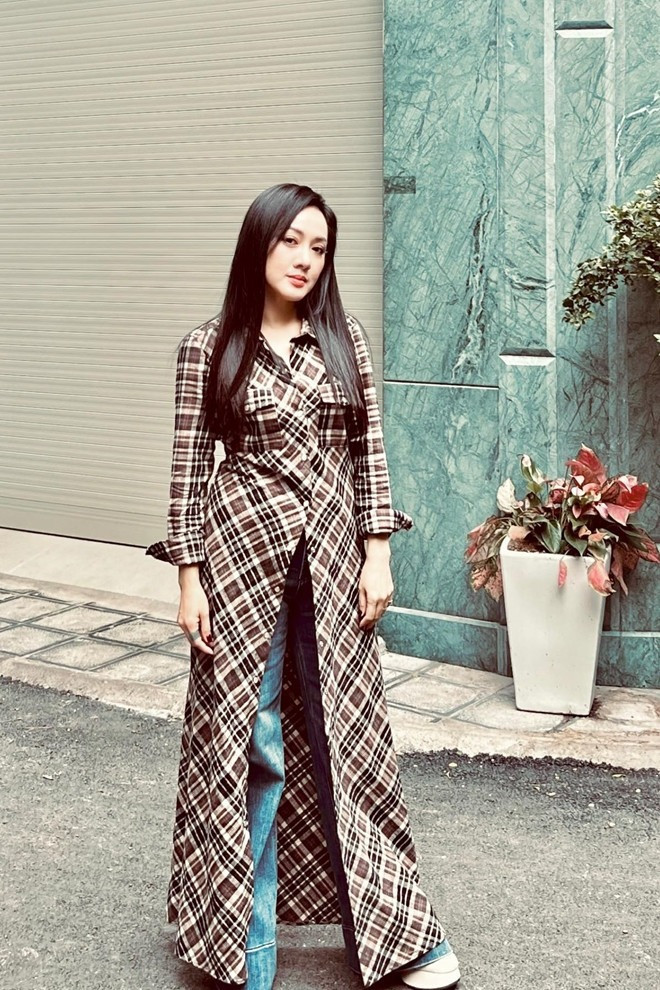 Hoài Anh thể hiện gu thời trang hiện đại, cá tính với áo khoác kẻ sọc dáng dài kết hợp quần jeans.