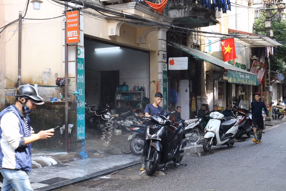 Có mặt tại tuyến phố tập trung nhiều cửa hàng rửa xe tại Hà Nội là phố Nhà Hỏa, hàng trăm chiếc xe đủ chủng loại, giá tiền nằm chờ xếp hàng để được "tắm rửa".