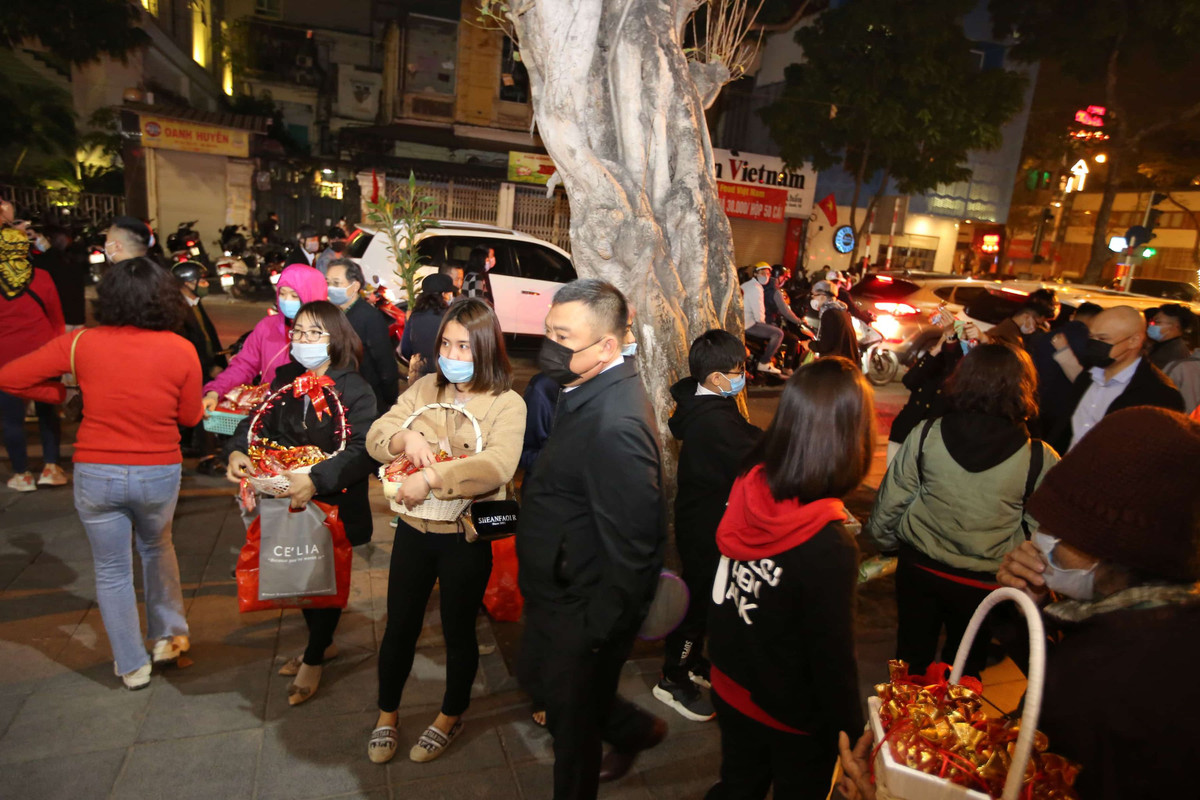 Phía bên ngoài cổng chùa Quán Sứ, những bạn trẻ bán muối lộc đầu năm.