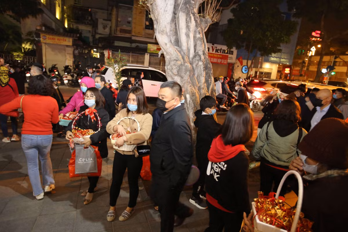 Phía bên ngoài cổng chùa Quán Sứ, những bạn trẻ bán muối lộc đầu năm.