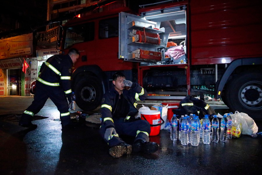 Nhiều chiến sĩ vẫn mặc nguyên bộ quần áo bảo hộ ướt sũng nước, khuôn mặt lấm lem, ám khói bụi, lộ vẻ mệt mỏi sau cả đêm trắng