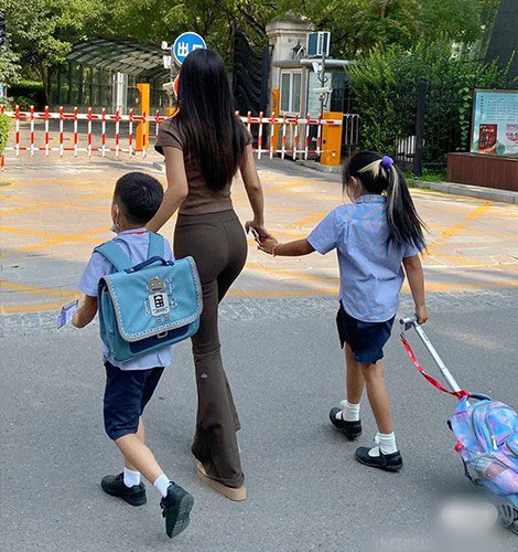 Bên cạnh trang phục váy ôm sát cơ thể, nhiều bà mẹ trẻ còn diện quần ống loe phối với áo thun có độ co giãn vừa vặn.