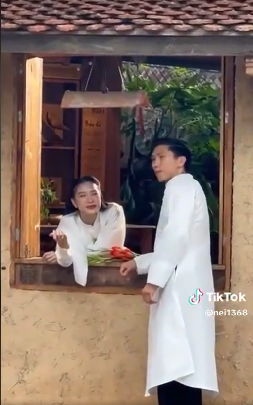 Đoàn Văn Hậu và Doãn Hải My cùng diện áo dài trắng, chụp ảnh theo phong cách cổ xưa. Gái xinh top 10 Hoa hậu Việt Nam tạo kiểu tóc và trang điểm tựa tiểu thư khuê các dịu dàng. Cô tựa cằm bên cửa sổ, đợi người thương ghé đến.