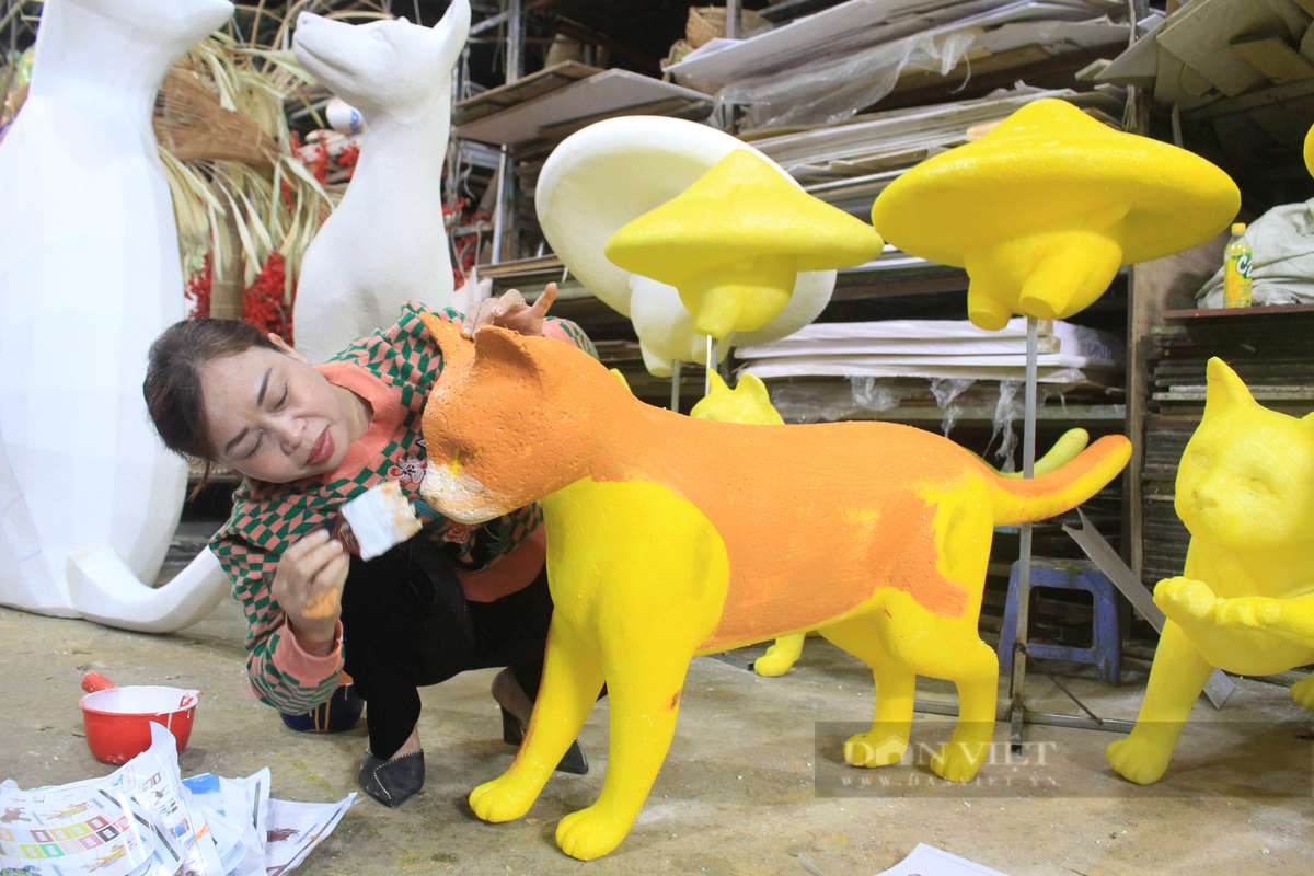Nghệ nhân Văn Tòng - người thực hiện linh vật chính đường hoa Nguyễn Huệ Tết Quý Mão 2023, kiểm tra các linh vật mèo xuất hiện tại cổng chính của đường hoa. Ảnh: Dân Việt