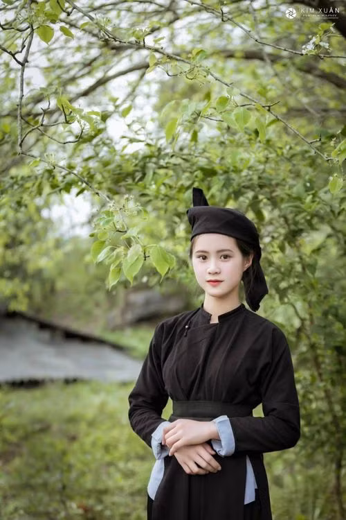Trong ảnh, cô gái diện trang phục của người phụ nữ dân tộc Tày với chiếc áo dài đen kết hợp thêm khăn đội đầu vô cùng giản dị nhưng toát lên sự duyên dáng, nền nã.