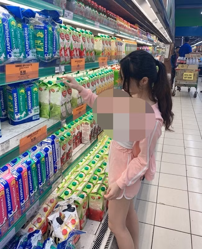 Diện áo khoét sâu, cô gái vô tư đứng chọn sữa trong siêu thị.