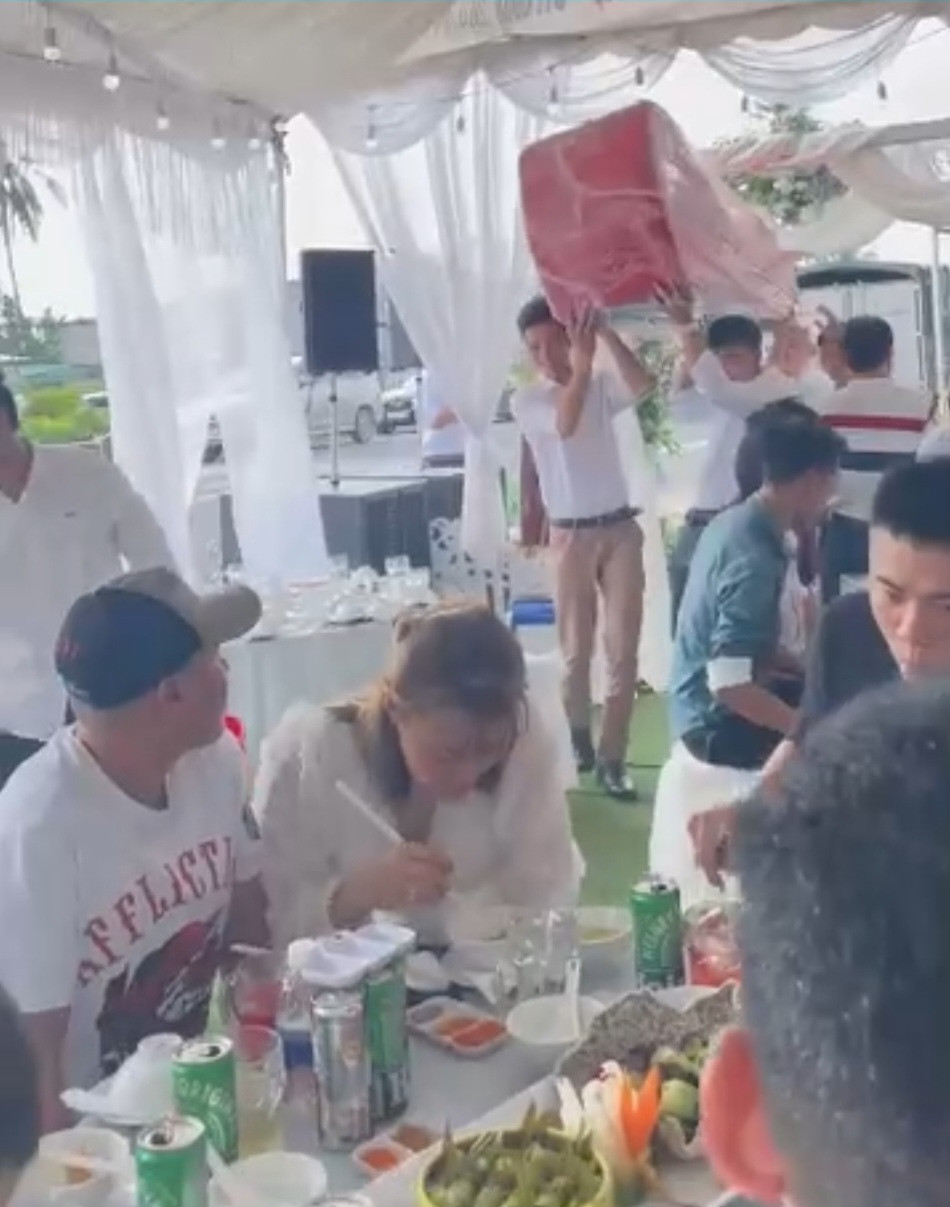 Theo clip, tất cả khách mời tới dự đám cưới đều trầm trồ khi thấy nhóm người từ cổng tiến vào hôn trường. Đó là một nhóm các thanh niên diện sơ mi trắng đang mang theo món quà cưới "khủng" tới tặng cho cô dâu chú rể.