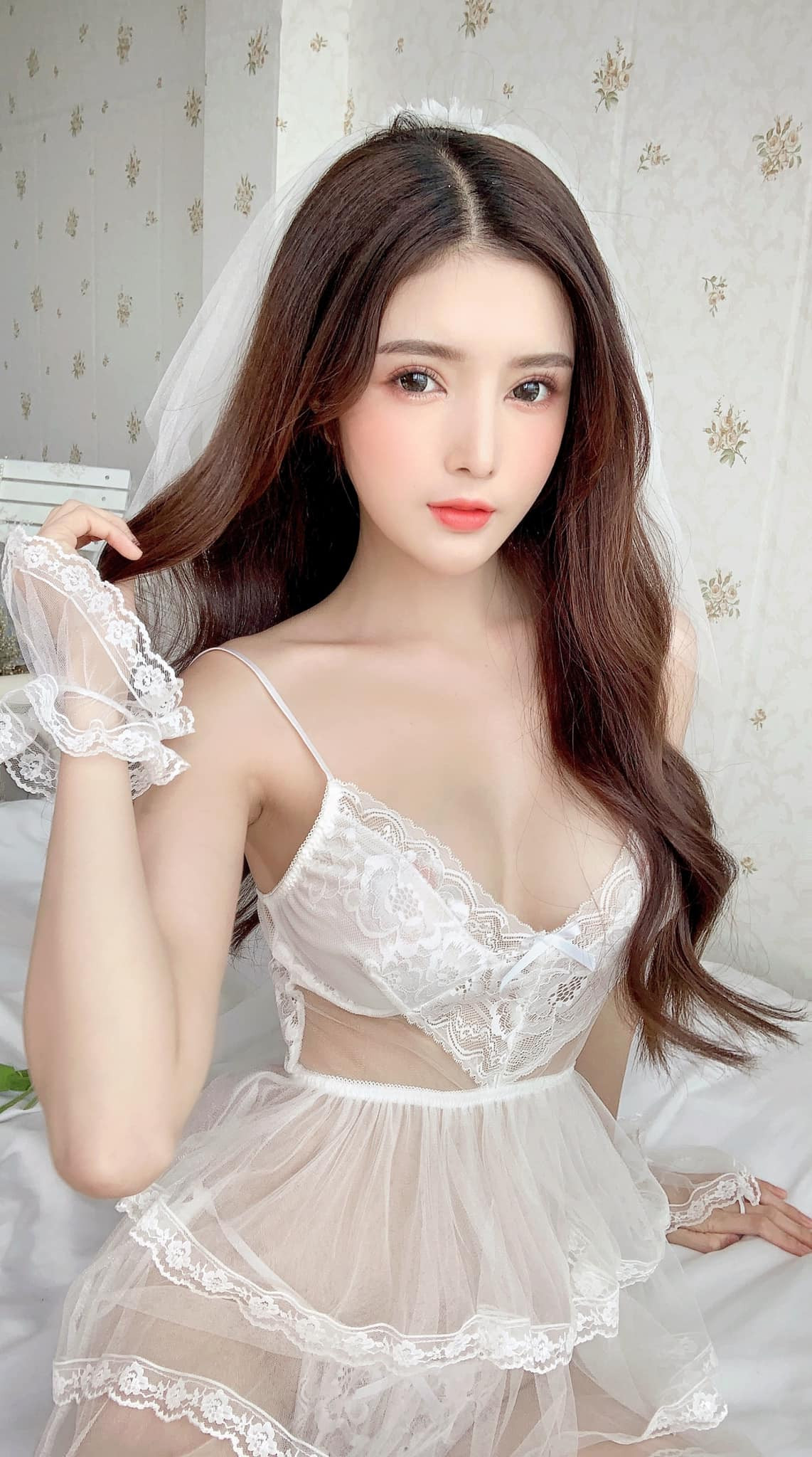 Trong bức ảnh mới nhất,Lilly Luta diện chiếc váy trắng bạc xếp ly khá nữ tính. Chiếc váy có thiết kế phần trên dạng yếm, để hở toàn bộ phần lưng trần nõn nà.