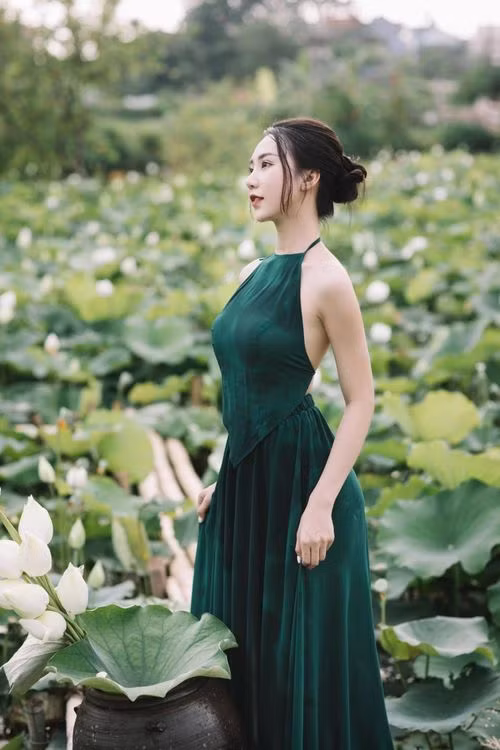 Trong khoảnh khắc chụp ảnh hoa sen của mình, Hồng Nhung chọn trang phục áo dài trắng và váy yếm màu xanh tôn lên vóc dáng và làn da trắng không tì vết của mình. Từ cách tạo dáng đến thần thái, biểu cảm trước ống kính đều “đốn tim” người xem bởi nhan sắc xinh đẹp, thanh tú cùng đôi mắt hút hồn.