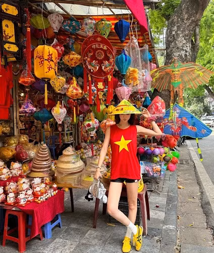 Jin Jin vừa có chuyến du lịch ở Hà Nội. Cô mặc áo tank top màu đỏ, in sao vàng cùng quần short đen.