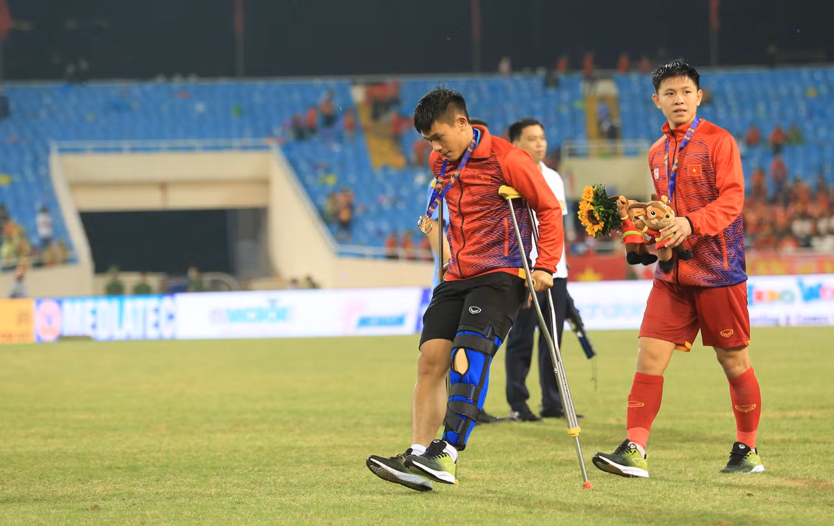 Dù đi lại rất khó khăn và phải nhờ đến đôi nạng nhưng Lê Văn Xuân vẫn cố gắng lên nhận HCV cùng với các đồng đội.