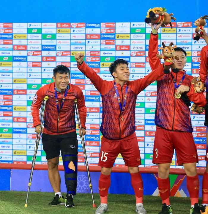 Khi các đồng đội hò reo, nhảy nhót ăn mừng, Văn Xuân chỉ đứng cạnh bên và nở nụ cười tươi