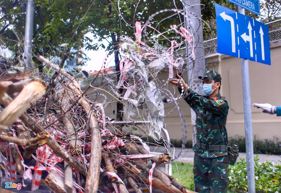 Lực lượng quân đội phối hợp với công an, dân phòng giúp cho công việc gỡ rào chắn nhanh chóng hơn. Ảnh trên đường Nguyễn Thị Minh Khai lúc 11h.