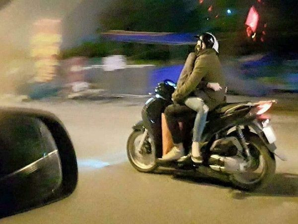 Một cặp đôi nữa điều khiển xe trong tình trạng ngồi "úp thìa" khi tham gia giao thông.