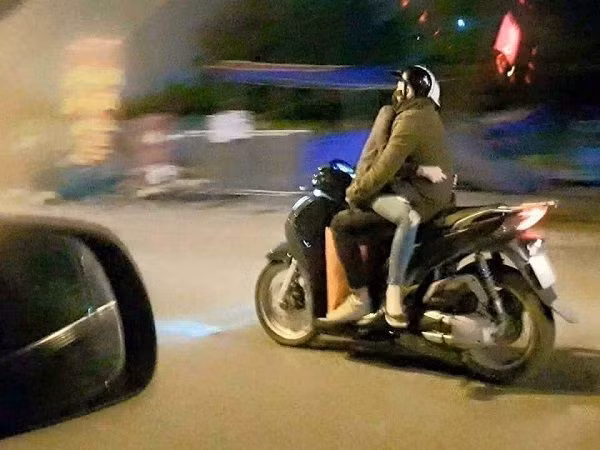 Một cặp đôi nữa điều khiển xe trong tình trạng ngồi "úp thìa" khi tham gia giao thông.