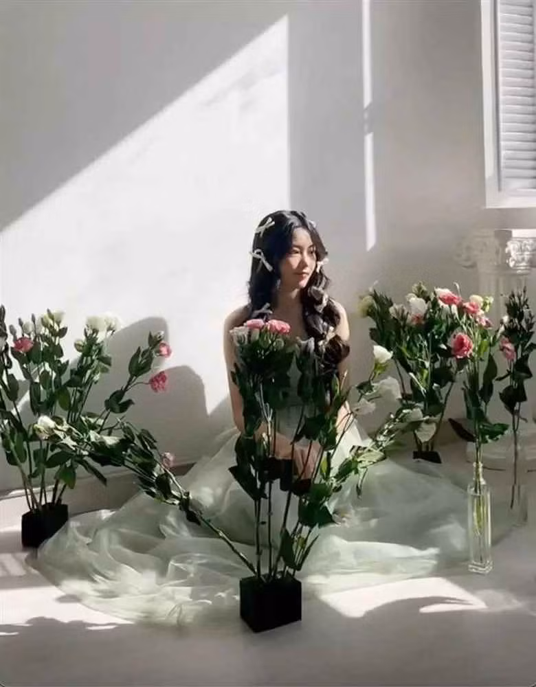 Xung quanh ngập tràn ánh nắng, Lọ Lem ngồi cạnh bên những lọ hoa rực rỡ trong đoạn clip được "team qua đường" quay lén.