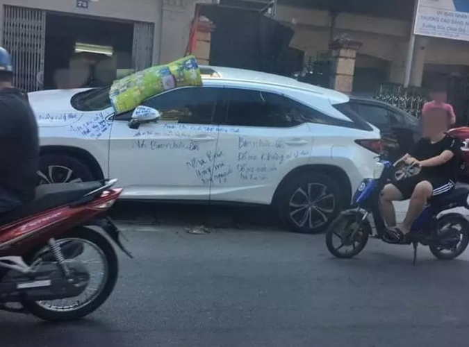 Đỗ xe chắn cửa nhà, chiếc xe màu trắng được chủ nhà tặng những dòng dằn mặt.