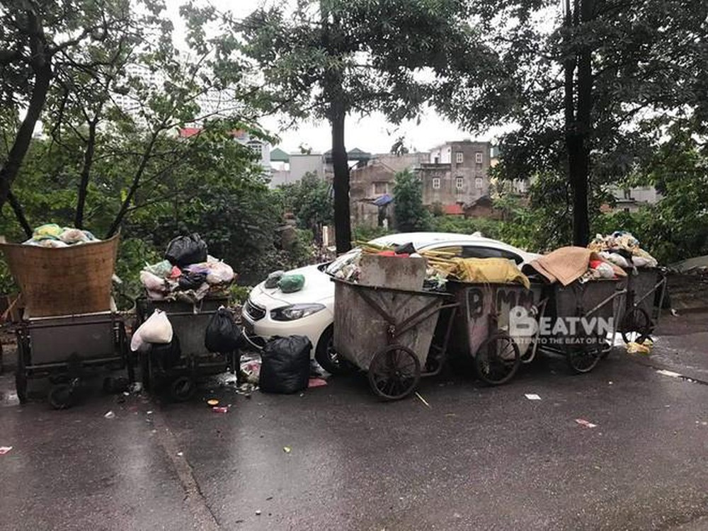 Hiện trường một chiếc ô tô màu trắng do đỗ vào vị trí bãi tập kết xe rác nên bị bao vây.