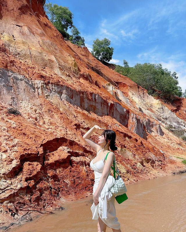 Theo đó, trong hình cô check-in tại Suối Tiên, Phan Thiết. Cô diện áo hai dây màu trắng với phần xẻ cổ sâu, phối cùng chân váy dài.