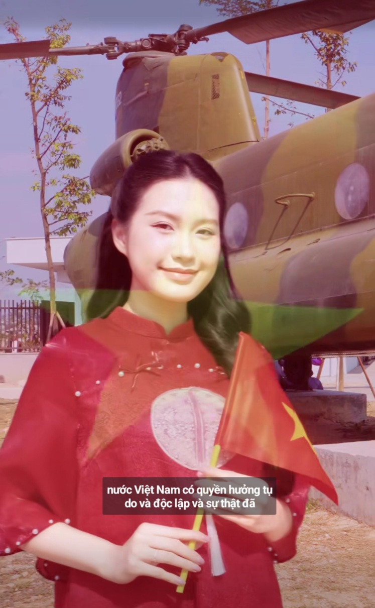 Trong video, Doãn Hải My diện áo dài đỏ - trang phục truyền thống của dân tộc. Người đẹp còn mang theo lá cờ đỏ sao vàng cầm tay.