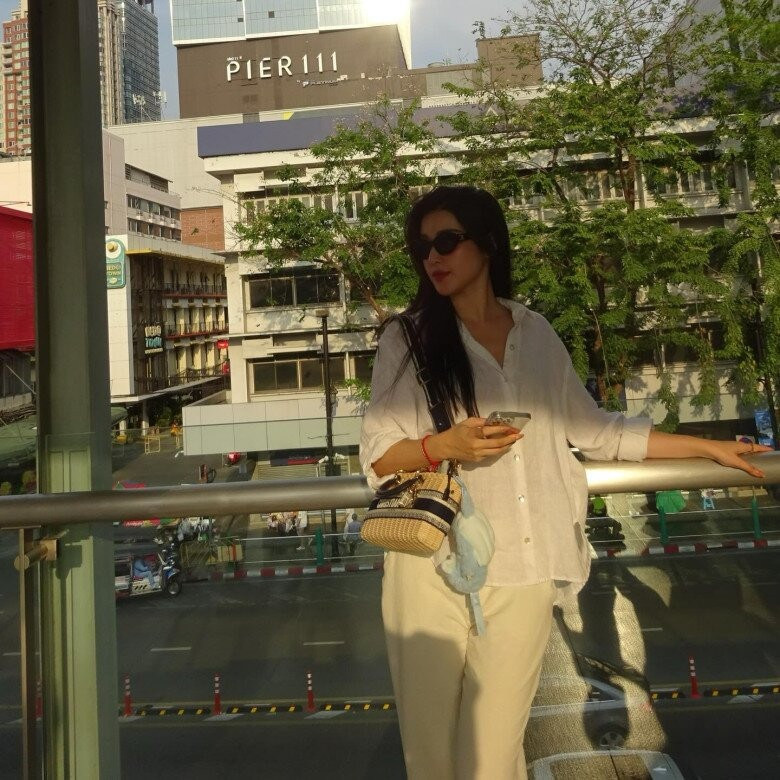 Xuất hiện ở Thái Lan khi đi mua sắm, Á hậu Huyền My chọn diện set đồ gồm áo sơ mi với quần dài màu trắng đơn giản, mỏng nhẹ.