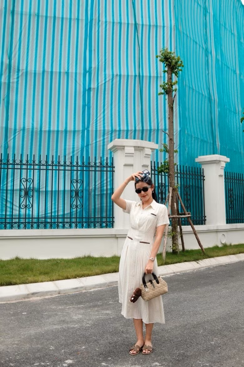 Chiếc váy trắng đơn giản được Huyền My phối cùng dép lê Hermès, túi xách Dior và đồng hồ đính kim cương tiền tỷ.