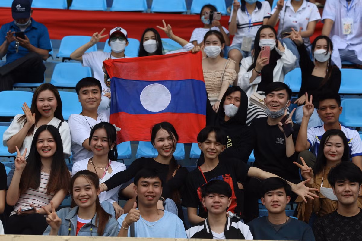 Hình ảnh nhóm học sinh Lào tại Việt Nam đã lặn lội từ Hà Nội tới Nam Định để cổ vũ các cầu thủ.
