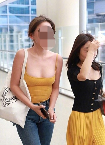 Nữ diễn viên Nhiệt Y Trát xuất hiện ở sân bay với trang phục gồm áo hai dây cổ sâu kết hợp với quần jean.