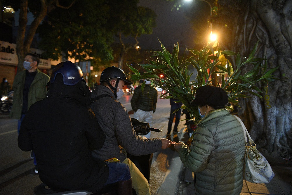 Ngoài cửa chùa Quán Sứ nhiều người dân dừng lại để mua những cành lộc và muối.