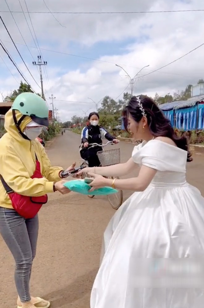 Thấy khách hàng của mình đang làm đám cưới, nữ shipper cũng rất bất ngờ. Cô cố gắng chạy thật nhanh đến để giao hàng. Còn người chứng kiến xung quanh không khỏi thích thú.