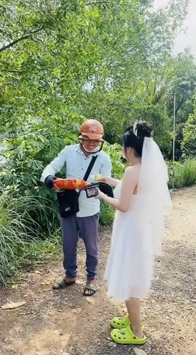 Nếu gặp trường hợp này có lẽ sẽ có không ít người hẹn shipper quay lại vào một hôm khác vì không tiện để lấy hàng. Thế nhưng cô dâu trong clip lại quyết định mặc nguyên bộ váy cưới ra nhận đồ trước khi đổi địa chỉ giao hàng về nhà chồng.