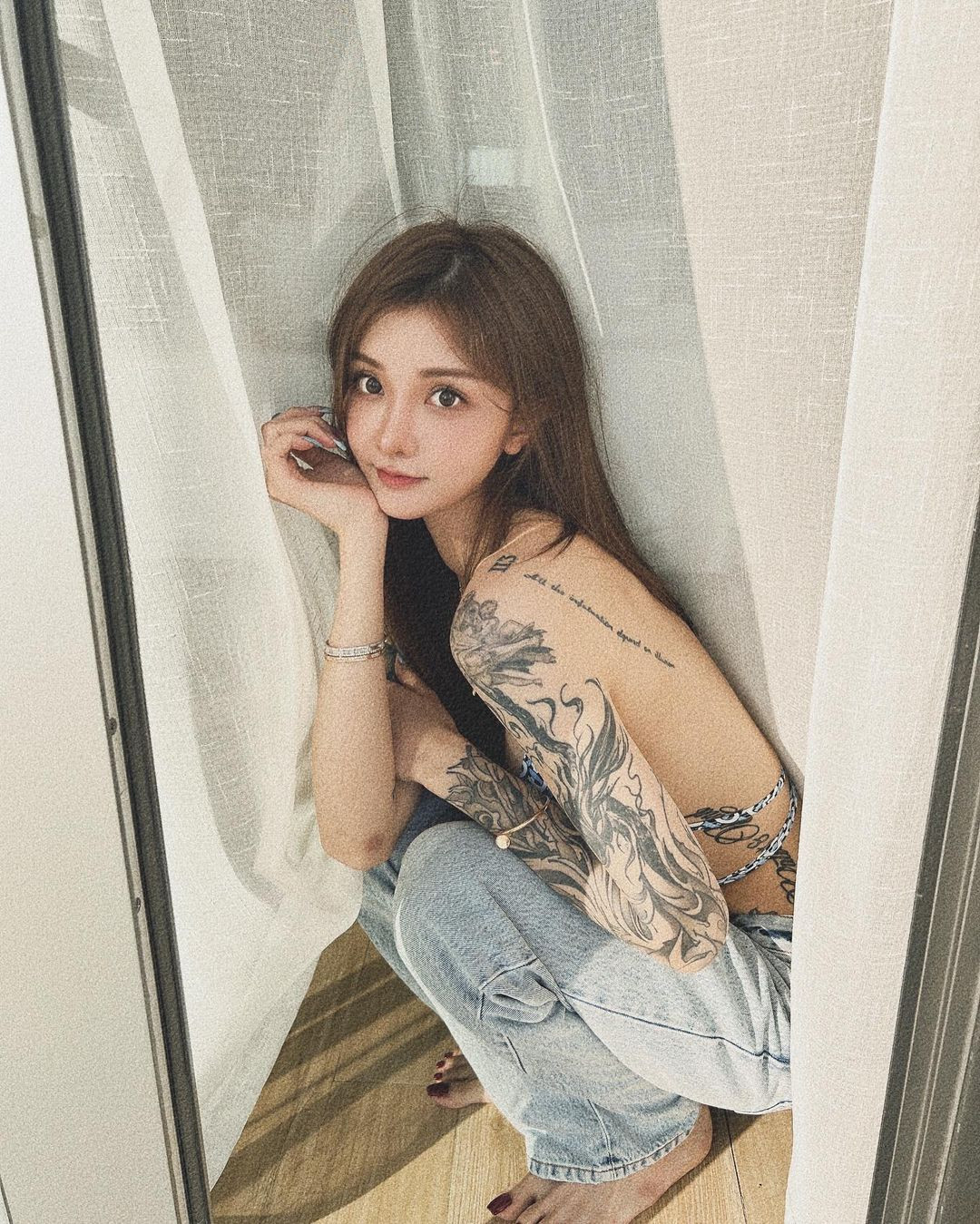 Thiết kế váy được làm từ chất liệu ren xuyên thấu, dáng đuôi cá thướt tha, kết hợp chi tiết khoét cổ sâu giúp hot girl xăm trổ xứ Trung này tôn triệt để vòng 1.