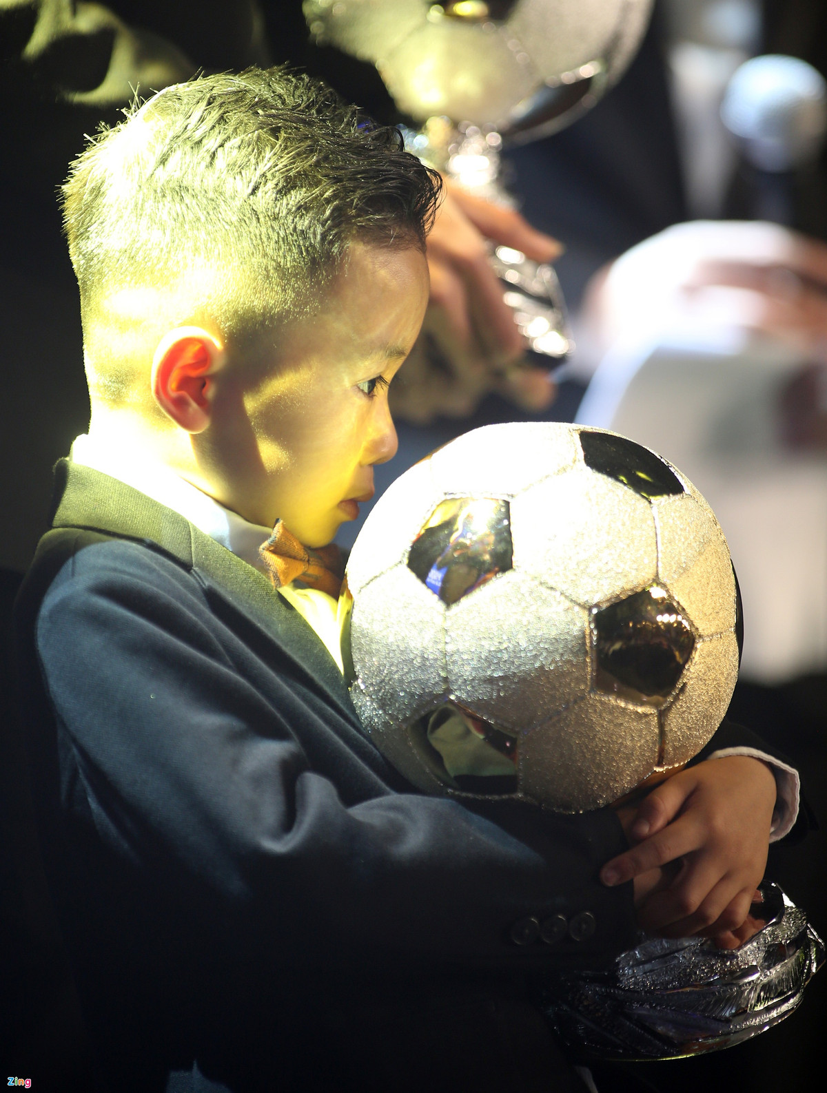 Con trai của Văn Quyết chiếm sự chú ý trên bục trao thưởng khi ôm chặt Quả bóng Vàng của đội trưởng CLB Hà Nội.