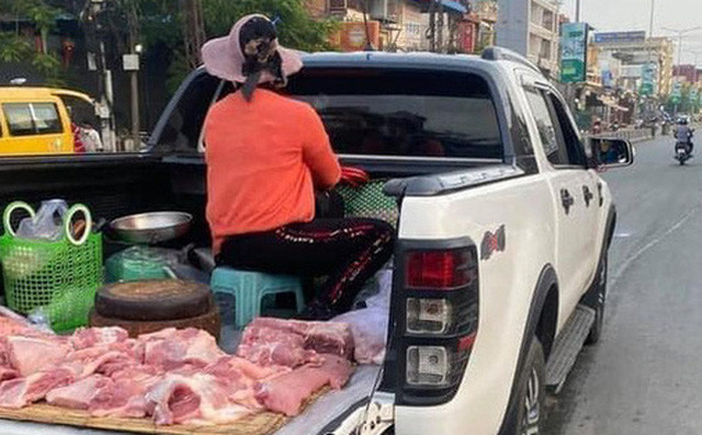 Sử dụng hẳn khoang sau của chiếc xe bán tải, chị tiểu thương bày biện sạp thịt, thớt, làn, túi… đầy đủ như một sân chợ nhỏ trên xe.