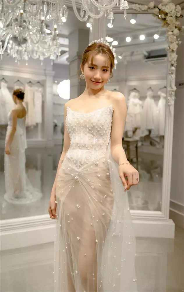 Khánh Huyền chọn thêm một mẫu đầm cưới lấp lánh những hoạ tiết nổi và lông vũ. Phần thân áo xuyên thấu mang đến vẻ đẹp nhẹ nhàng nhưng vẫn quyến rũ cho cô dâu.