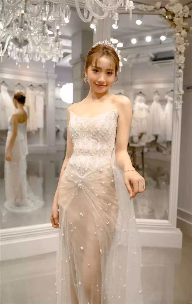 Khánh Huyền chọn thêm một mẫu đầm cưới lấp lánh những hoạ tiết nổi và lông vũ. Phần thân áo xuyên thấu mang đến vẻ đẹp nhẹ nhàng nhưng vẫn quyến rũ cho cô dâu.