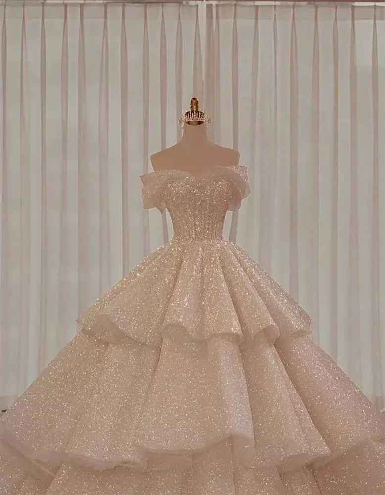 Váy cưới chính khi làm lễ thuộc dòng Limited Edition của một NTK trong nước được đính 5.000 viên pha lê Swarovski và 1.000 viên ngọc trai cao cấp. Bộ đầm có tông màu kem với thiết kế tùng váy ba tầng lộng lẫy.