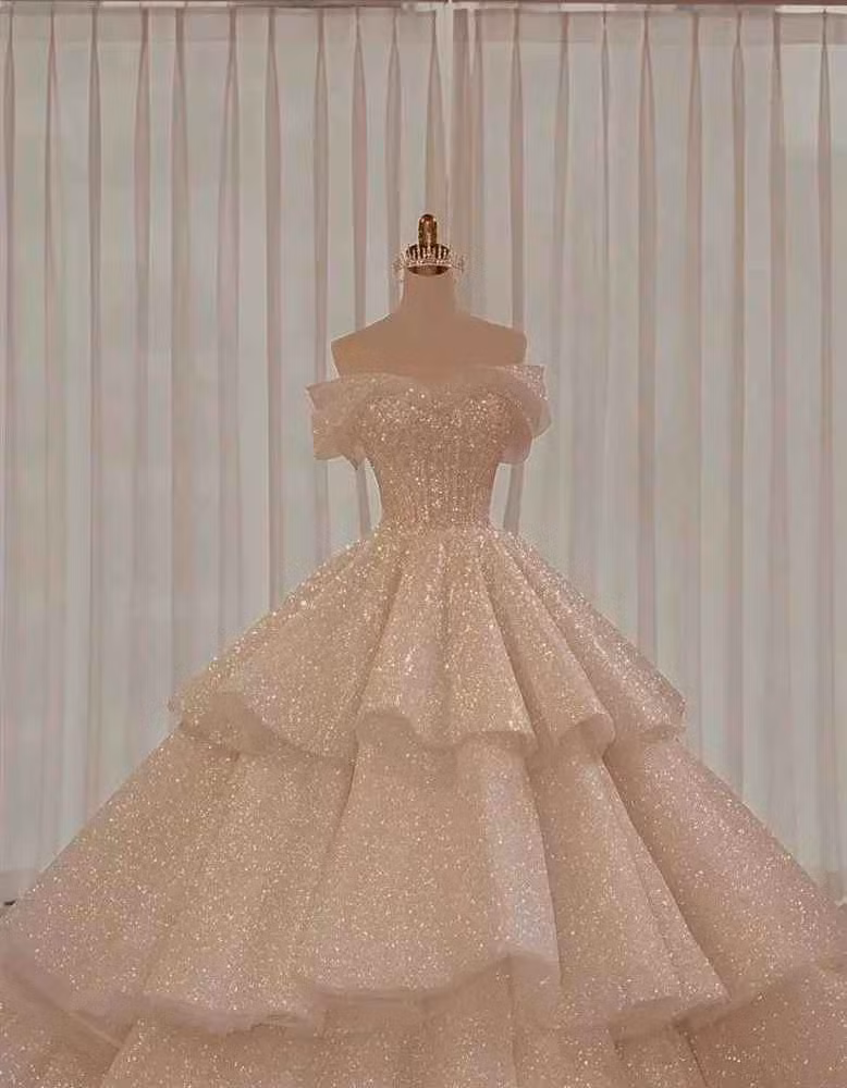 Váy cưới chính khi làm lễ thuộc dòng Limited Edition của một NTK trong nước được đính 5.000 viên pha lê Swarovski và 1.000 viên ngọc trai cao cấp. Bộ đầm có tông màu kem với thiết kế tùng váy ba tầng lộng lẫy.