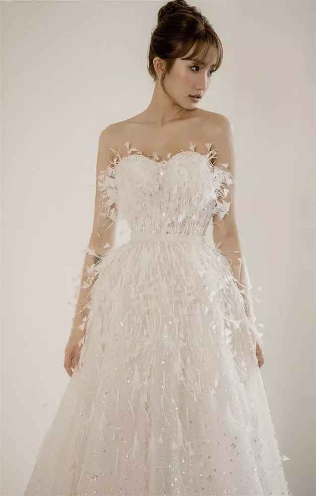 Trong đám cưới ở Quảng Ninh, hot girl Lê Thị Khánh Huyền mặc váy cưới cúp ngực đính lông vũ để đi chào bàn.