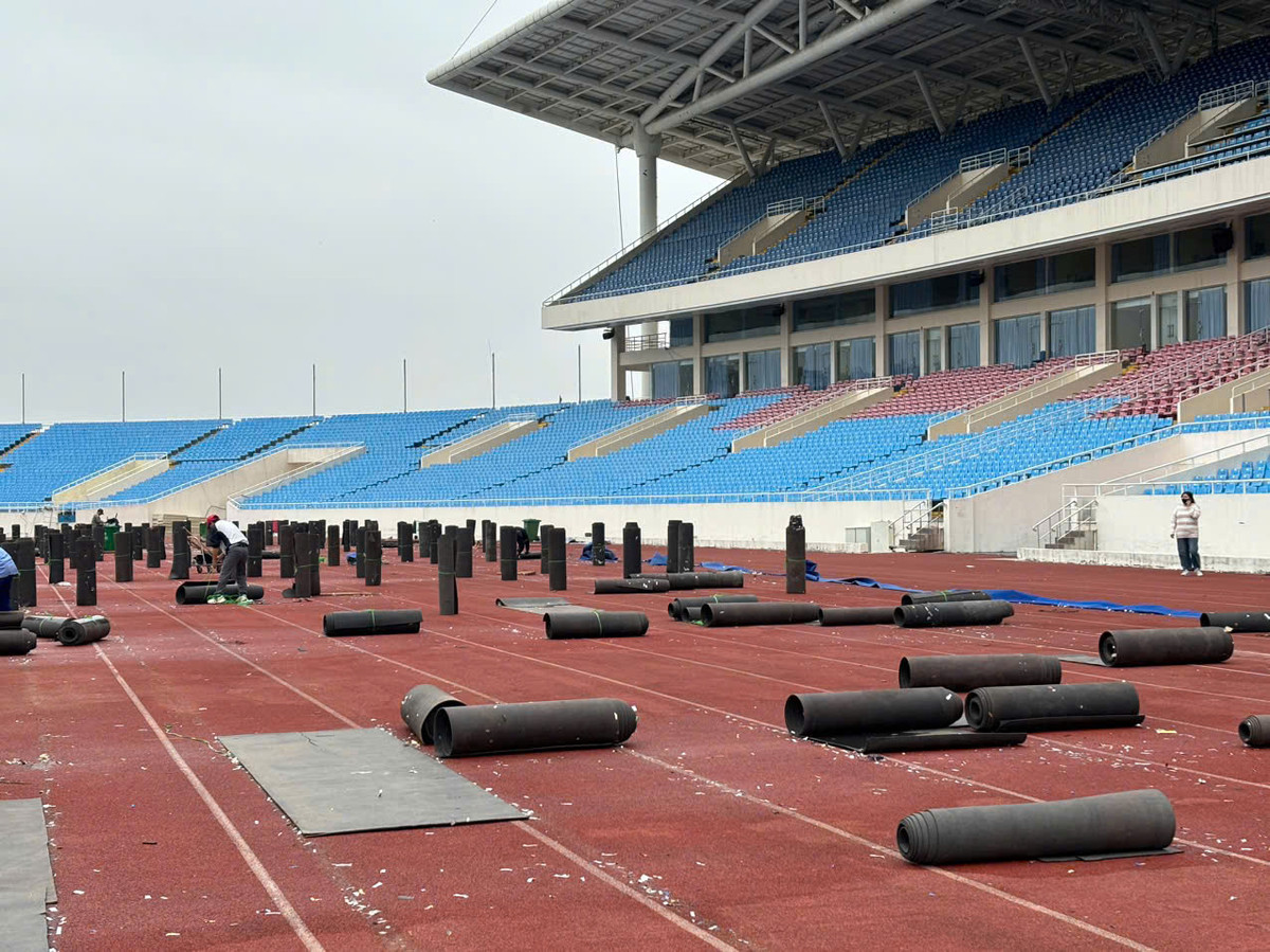 Các công nhân đang tiến hành thu dọn, cuốn gọn lại để di chuyển ra bên ngoài.